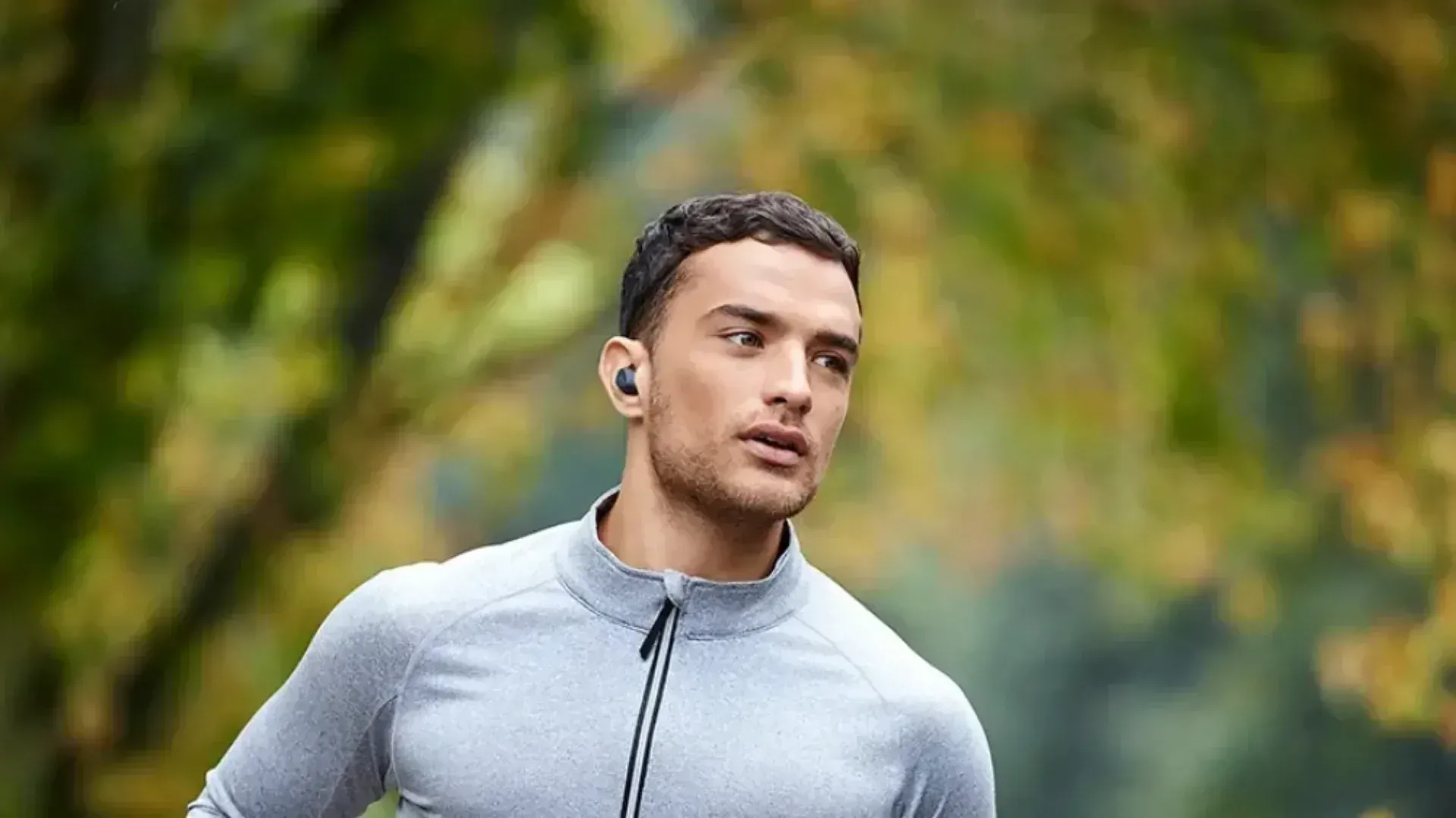 A man wearing in-ear wireless earbuds on a run