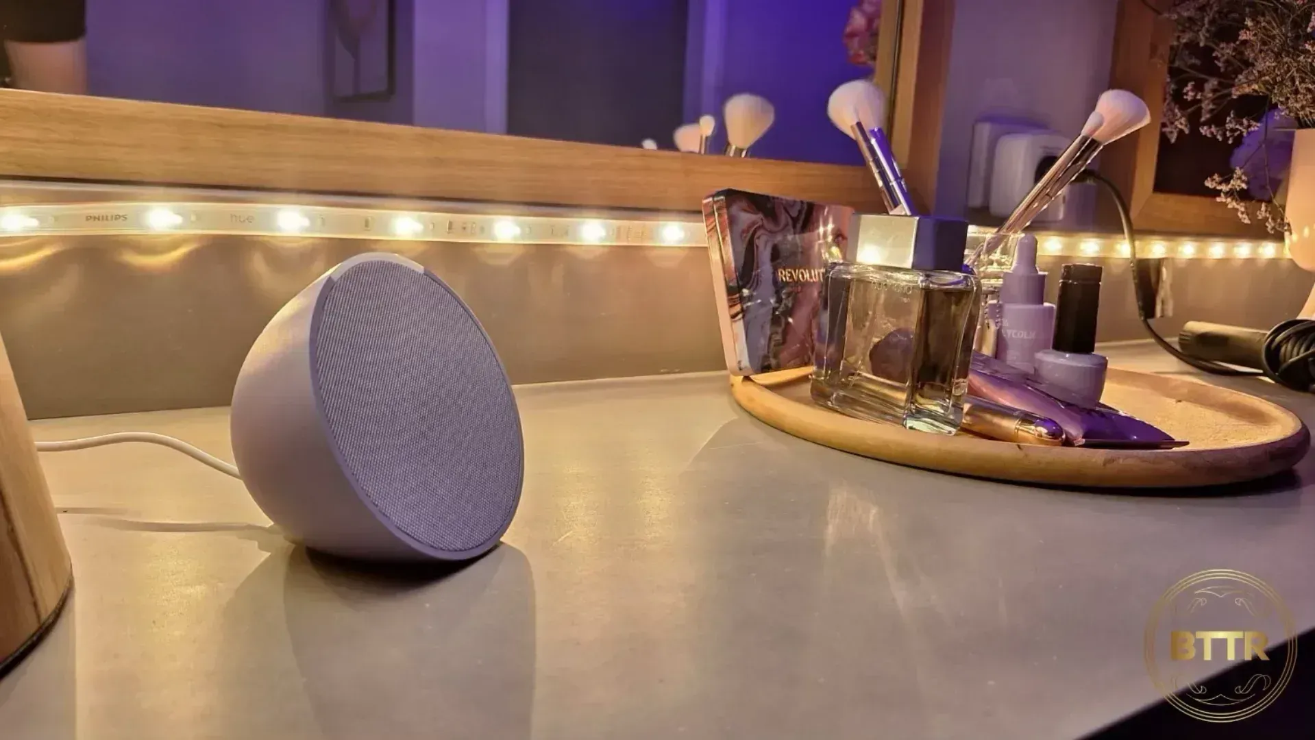 An Echo Pop on a bench in front of a mirror with a tray of makeup ready to be used.