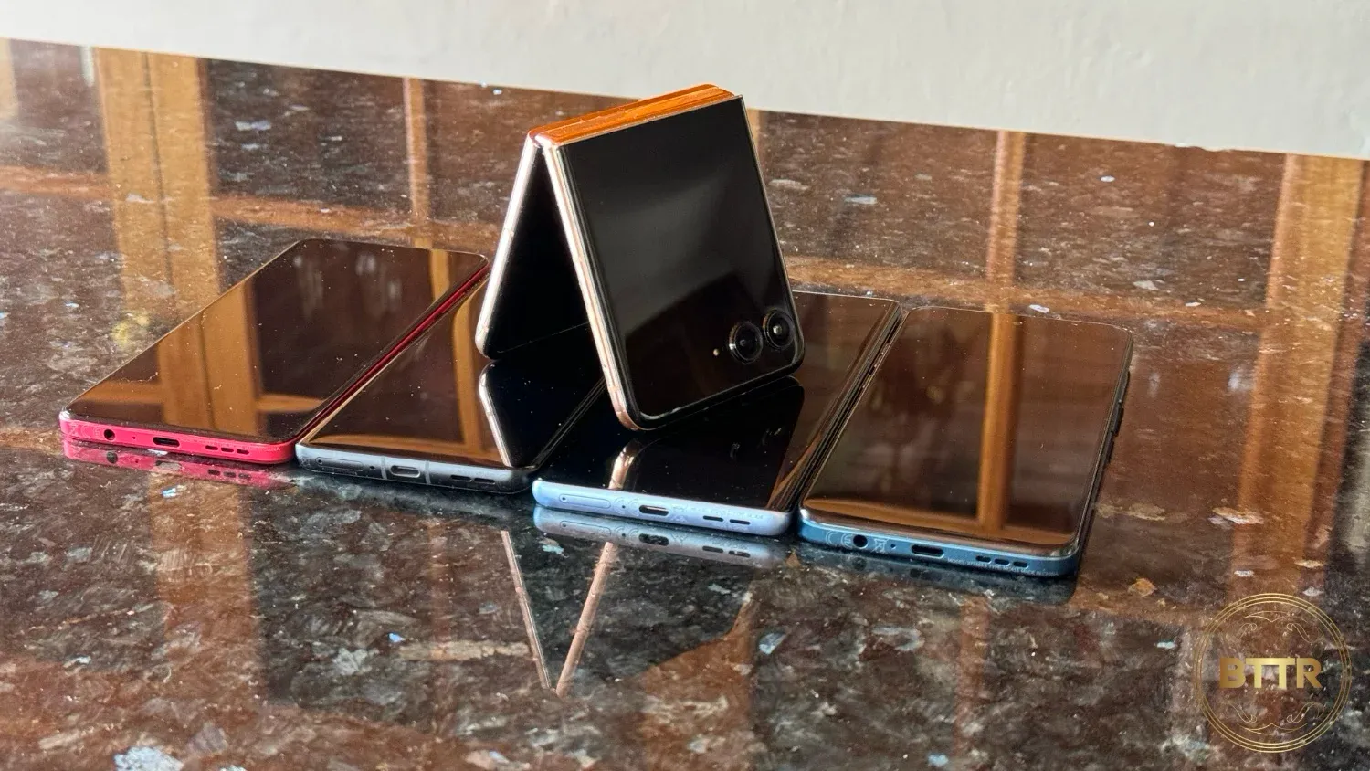 The Moto RAZR 50 Ultra folded and sitting on top of other Motorola phones