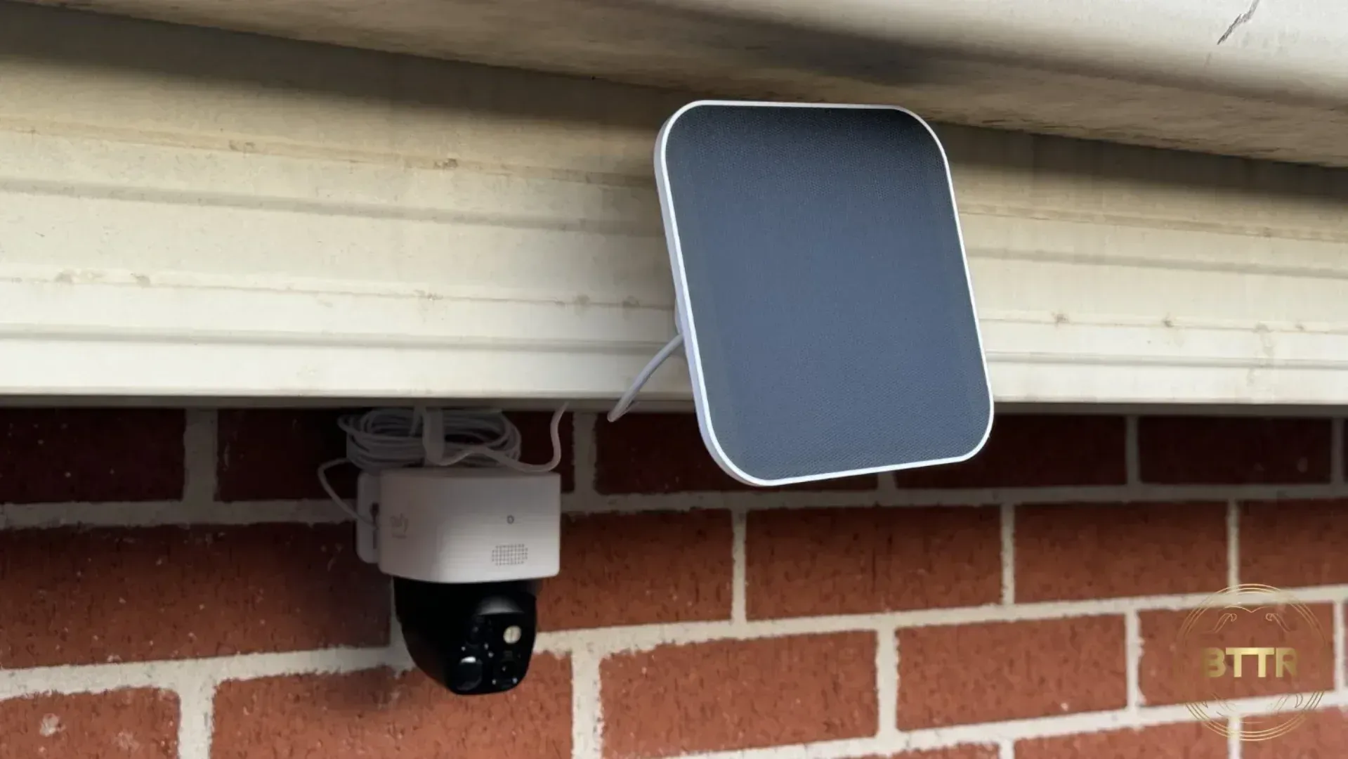 Eufy S340 solocam mounted on a brick wall with the solar panel attached nearby