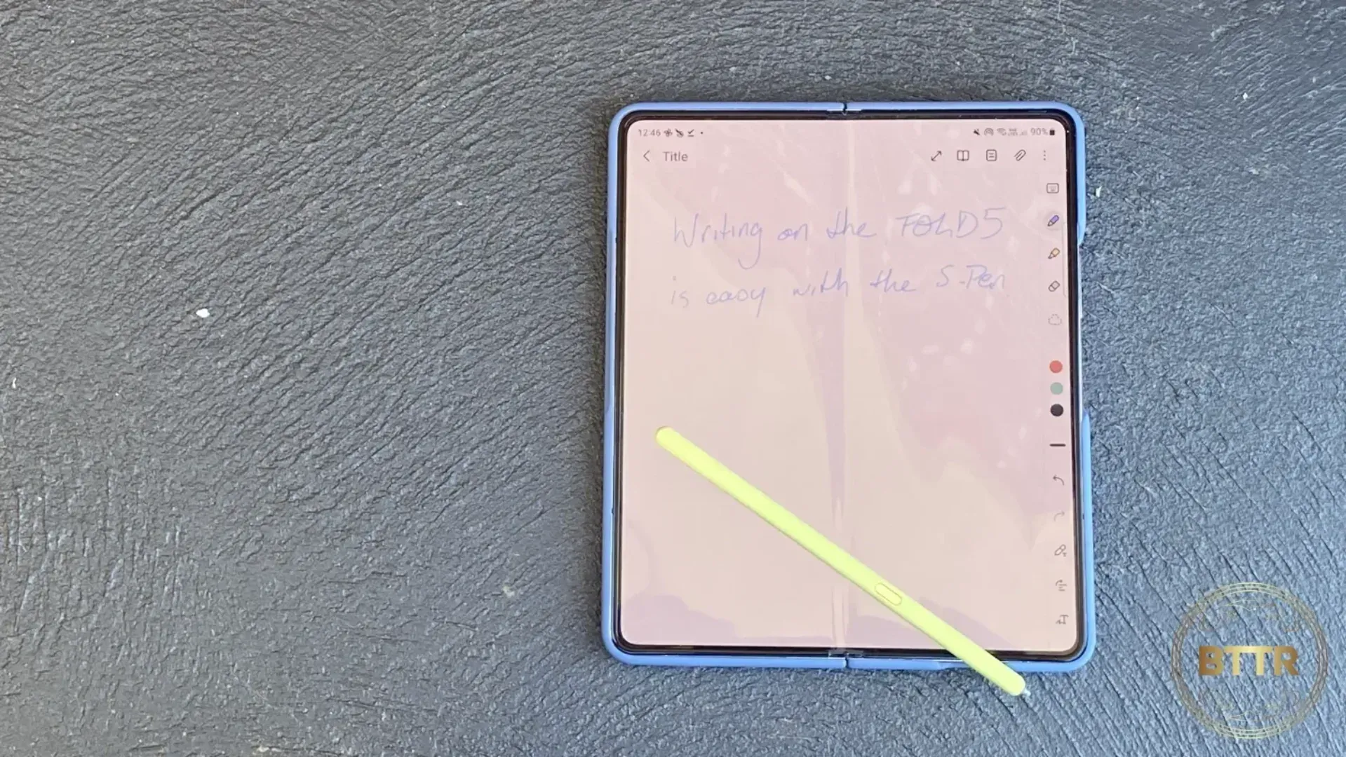 The Samsung Galaxy Z Fold 5 on concrete, open with the S-pen resting on the open screen