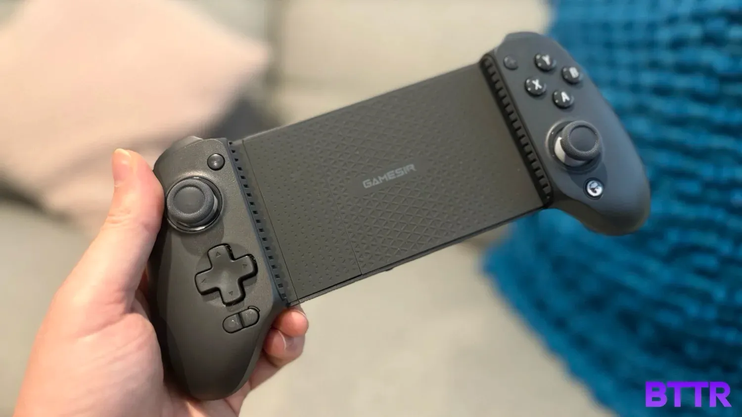 Holding the GameSir G8 Plus in front of some cushions