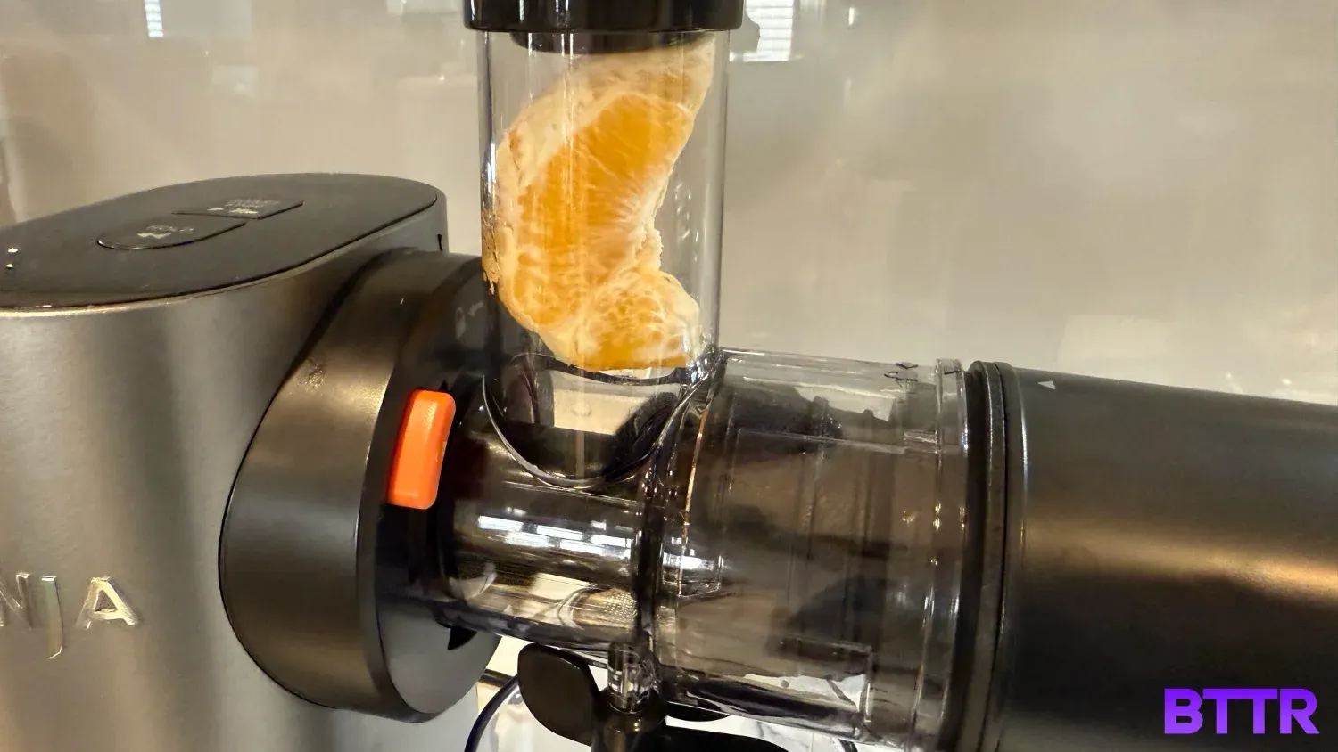 An orange segment ready to be squeezed for its juice in the Neverclog