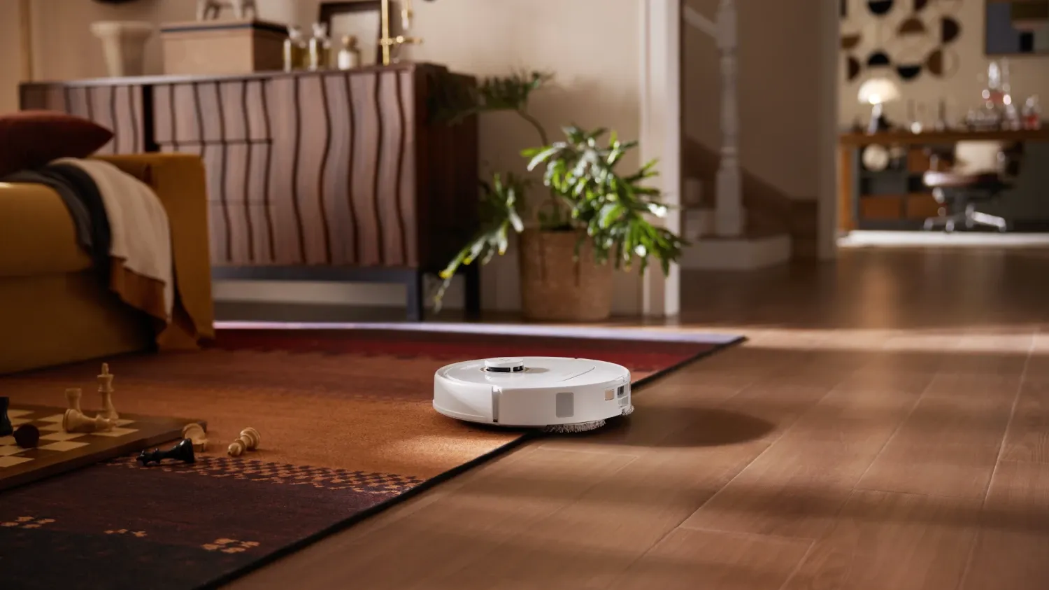 The new Qrevo C robot vacuum from roborock, cleaning a carpet with a chess board on it