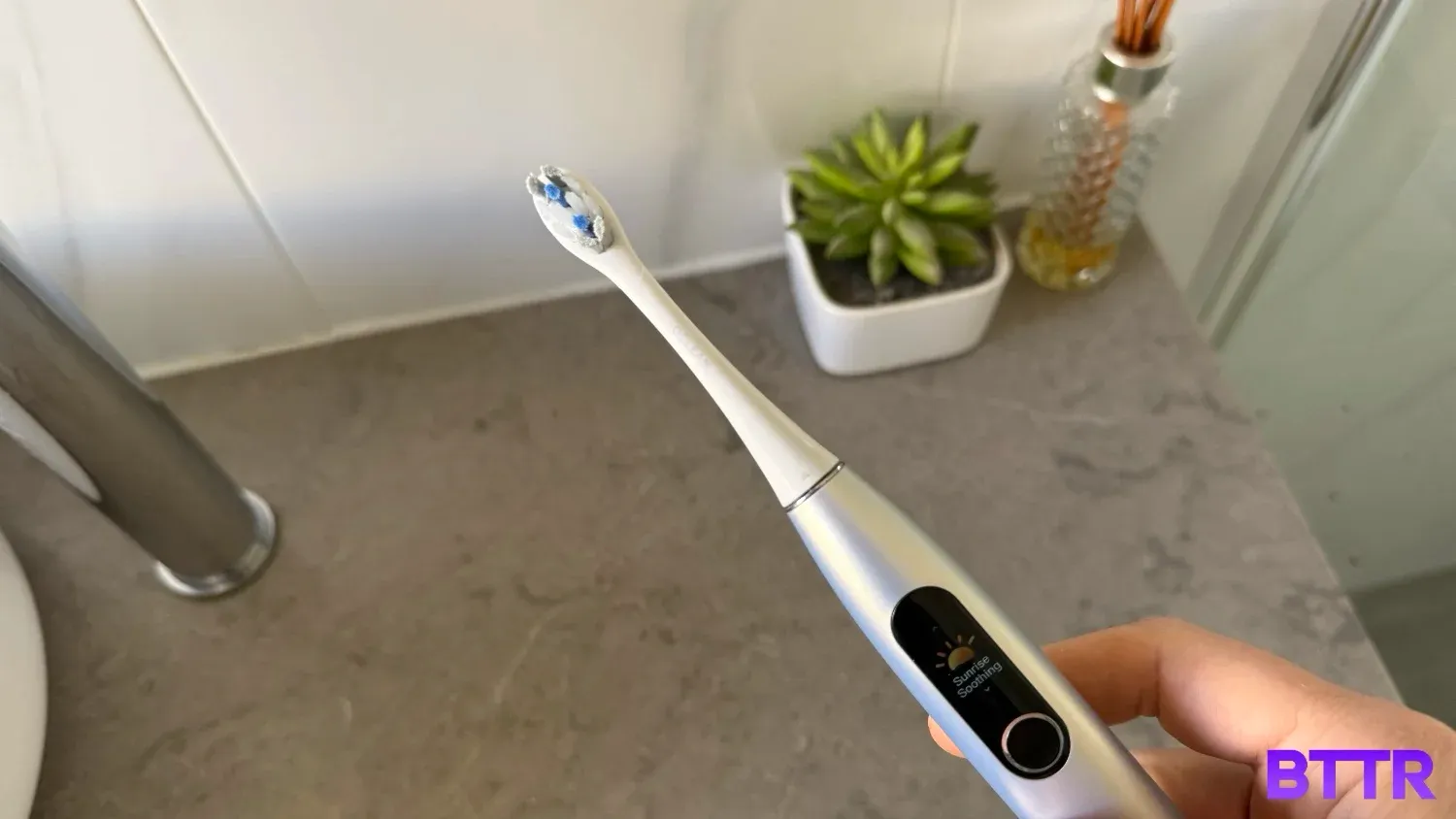 holding the Oclean X Pro Digital over my bathroom counter