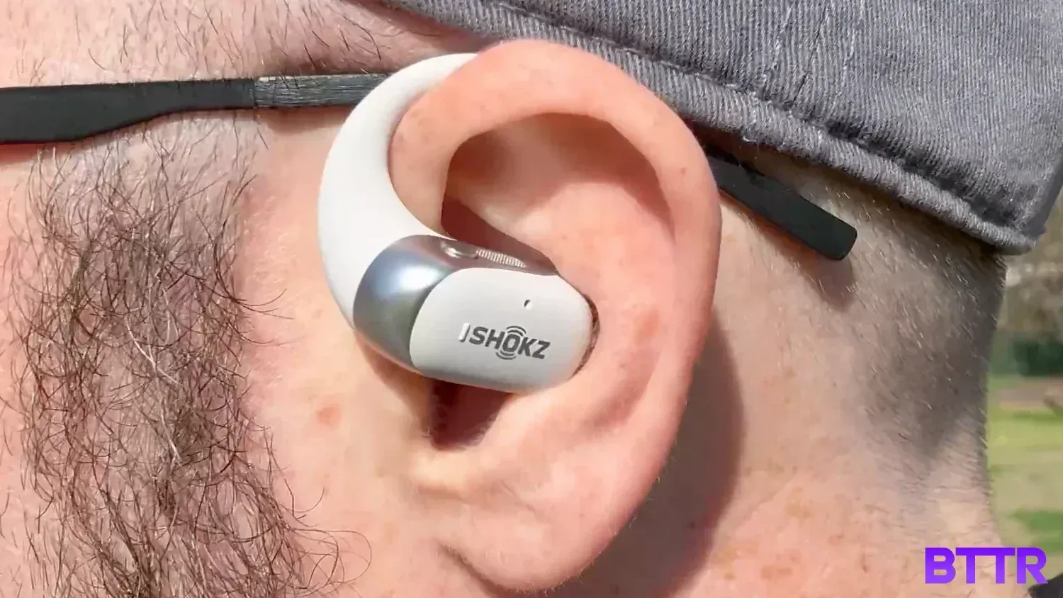 Close up of the Shokz OpenFit2+ while wearing glasses