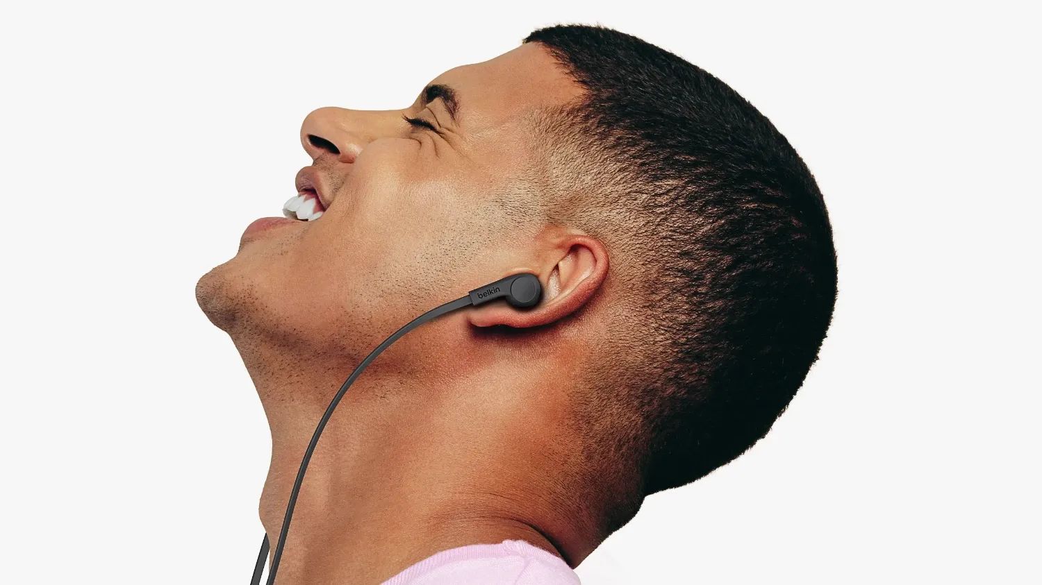 A man smiling as he looks up with the USB-C wired earbuds in from Belkin
