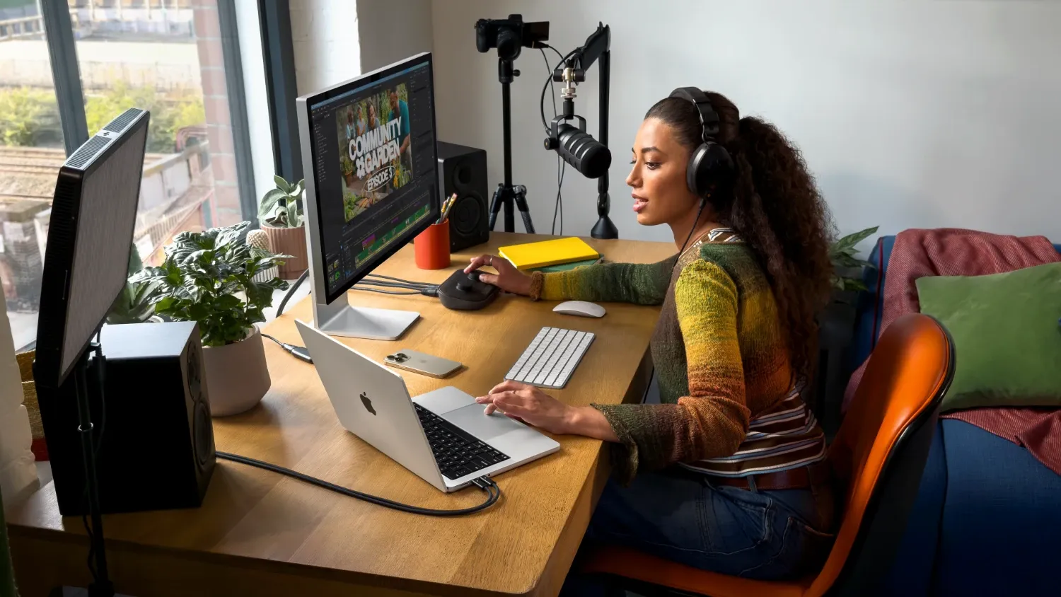 woman recording audio while looking at a macnook pro