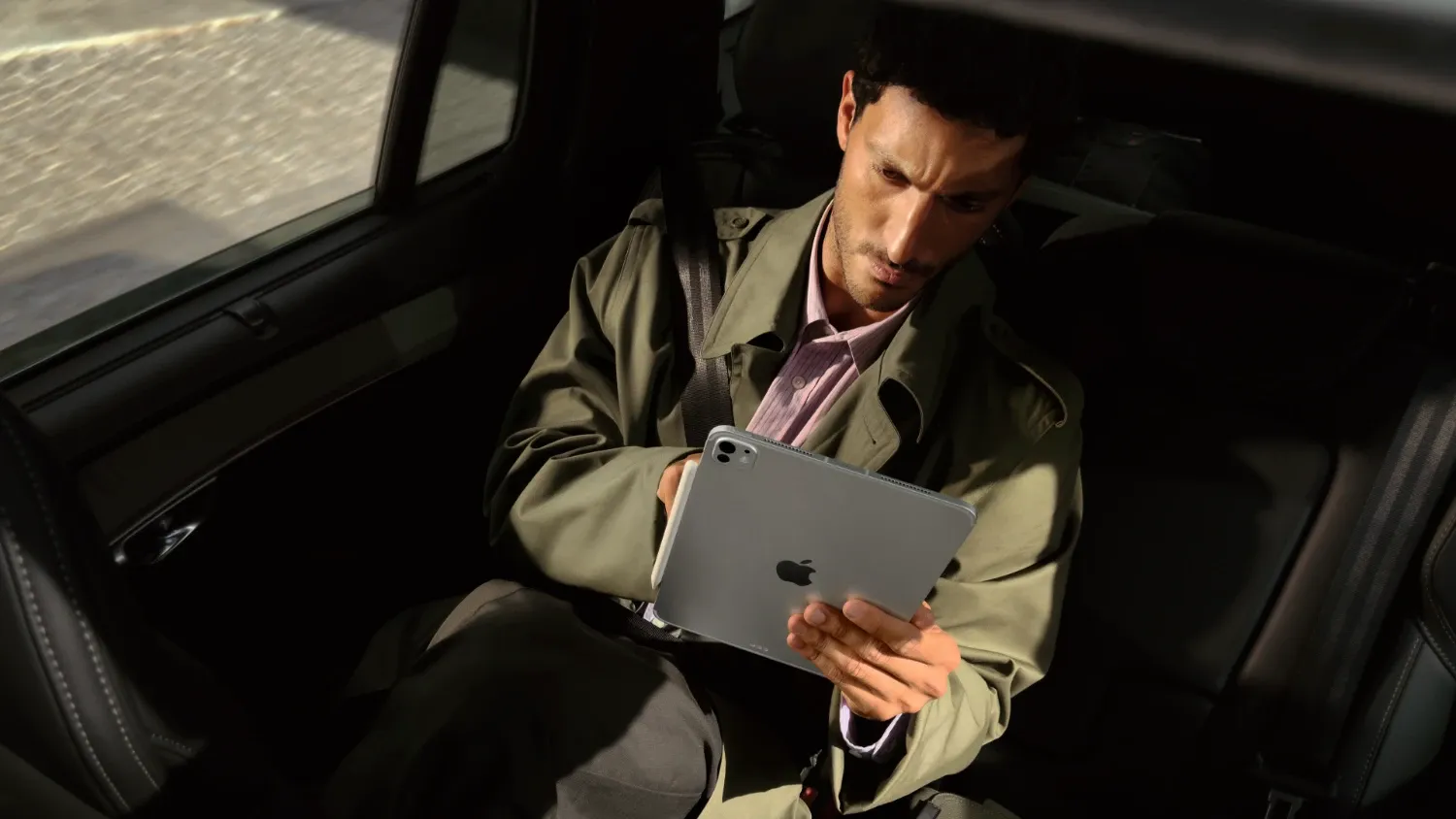 man using ipad pro in a car