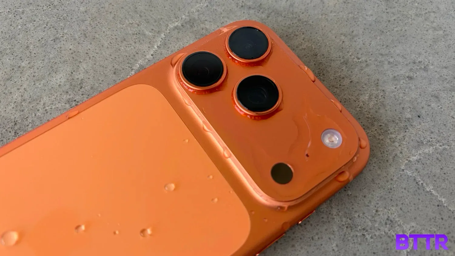 The back of the iPhone 17 Pro splashed with water