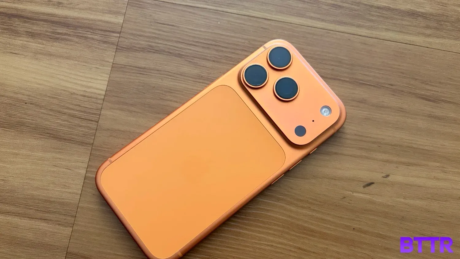 The 17 Pro lying on wooden floorboards