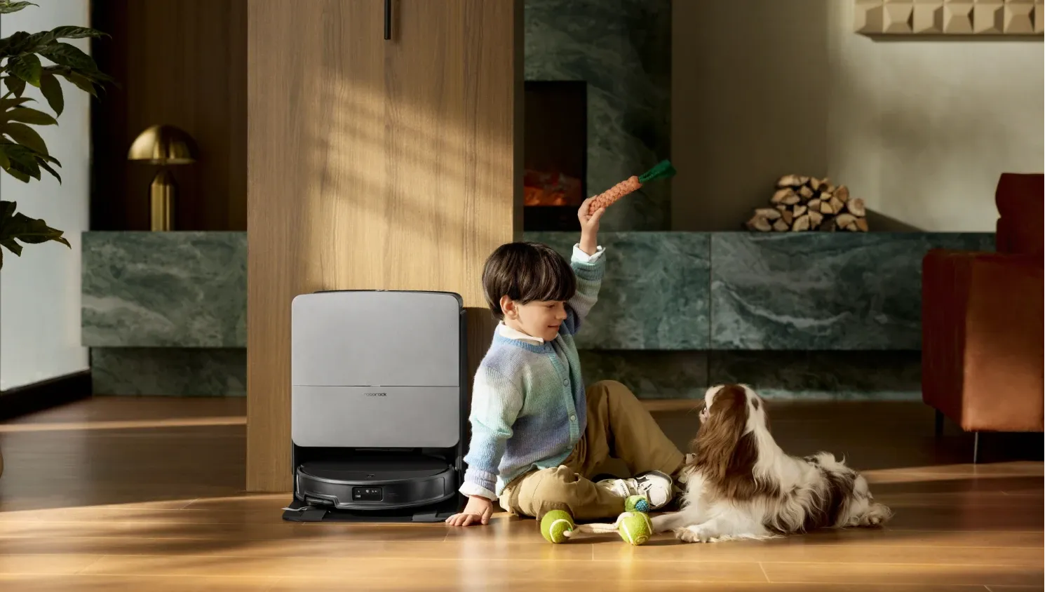 The Saros 20 from Roborock with a child and dog sitting next to it