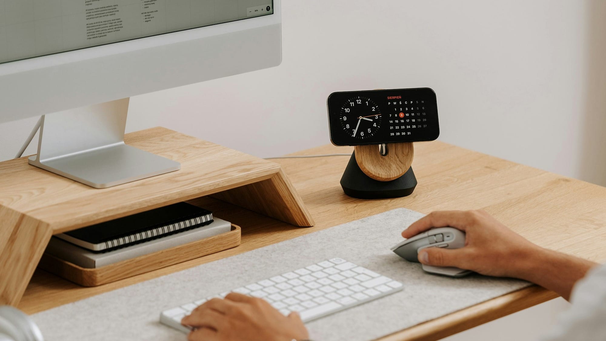 a person sitting at a desk with a mouse and keyboard