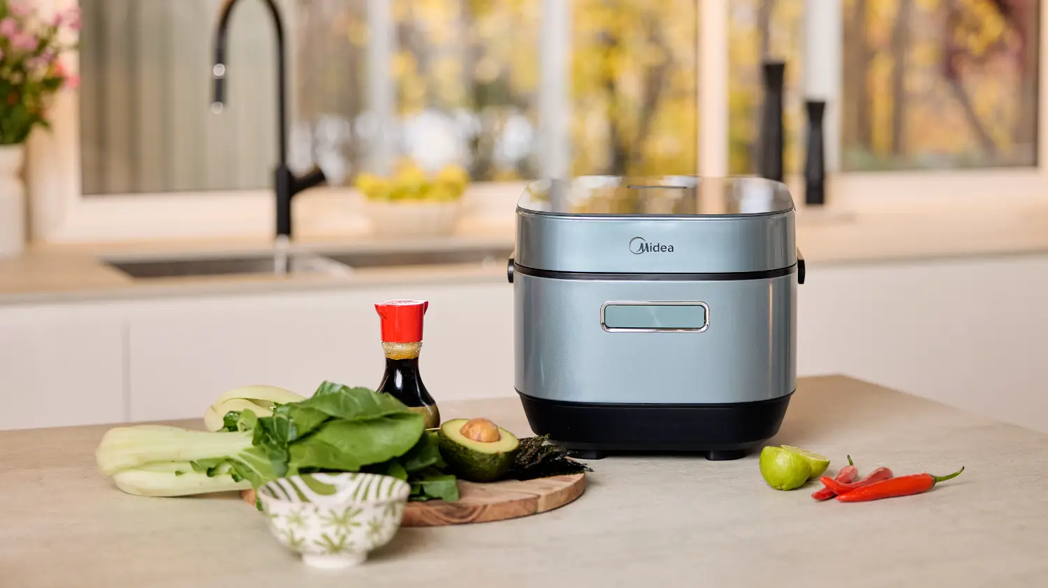 midea's rice cooker on a bench with asian ingredients