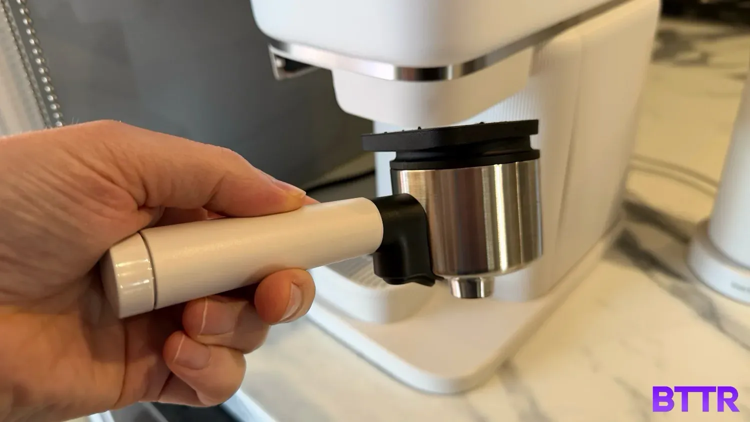 Holding the portafilter in front of the Philips Baristina
