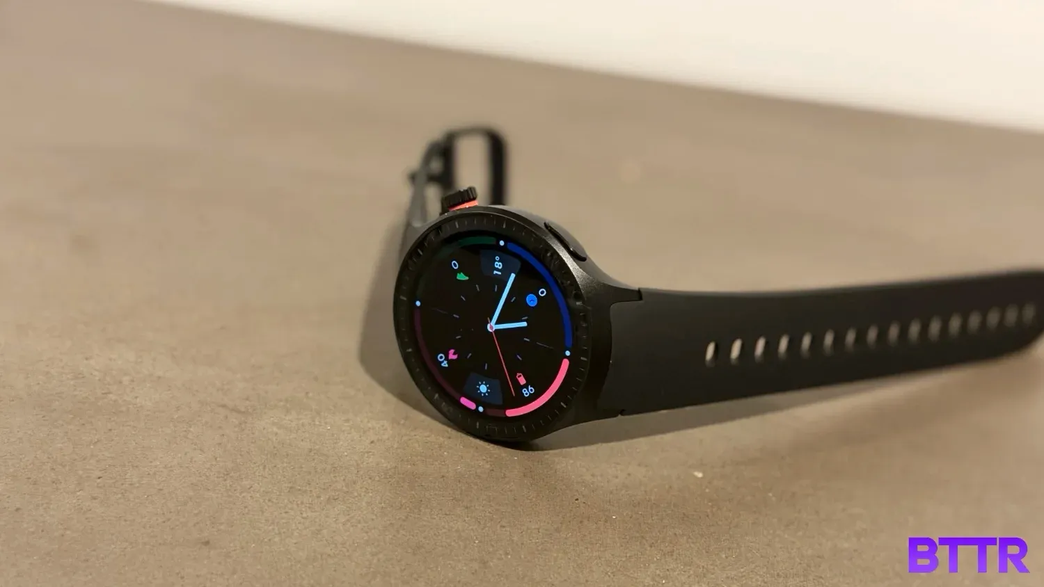 the moto watch with a silicone band sitton sideways on a concrete table
