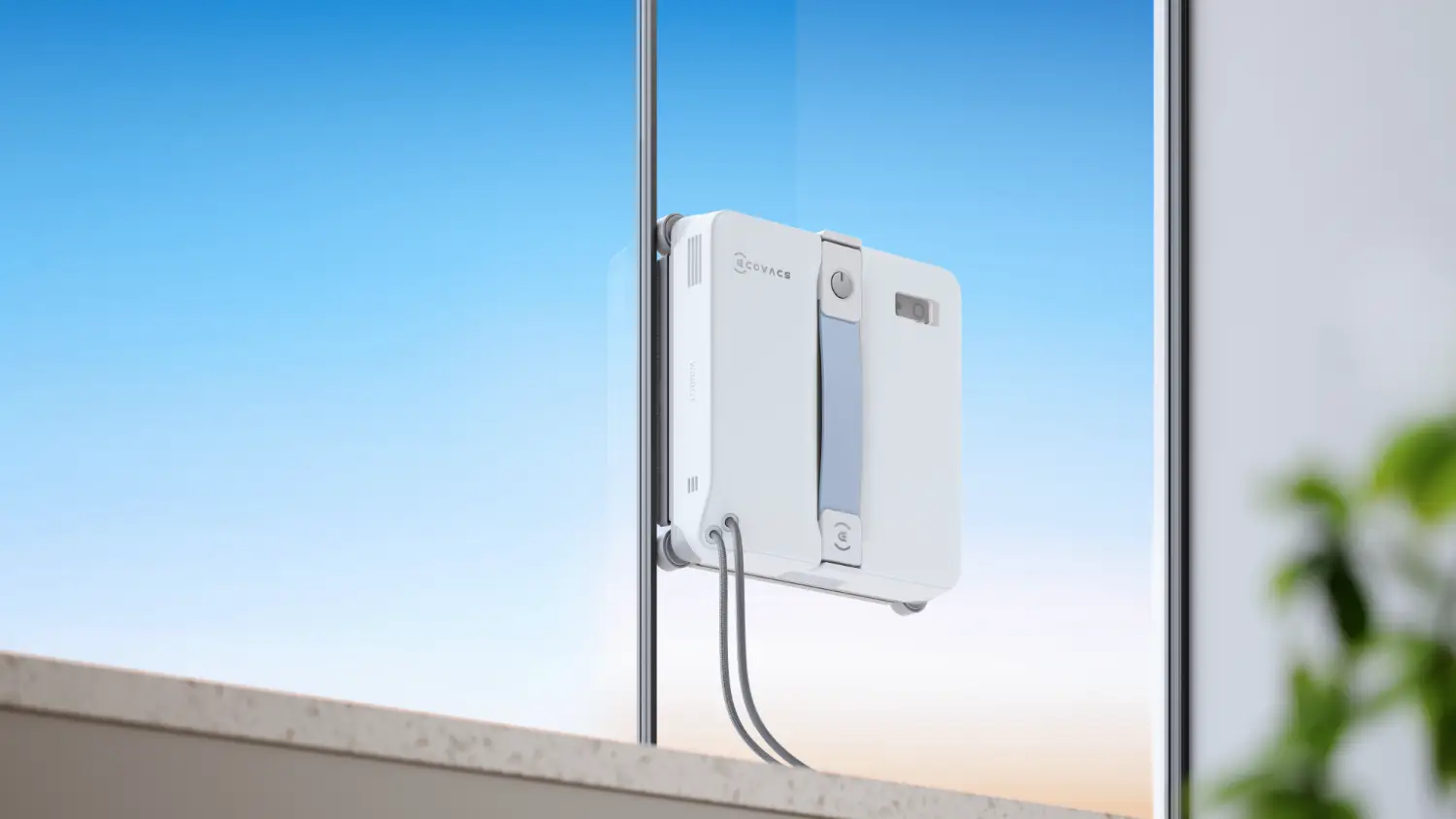 The Ecovacs Winbot Lite cleaning a window before a beautiful blue sky