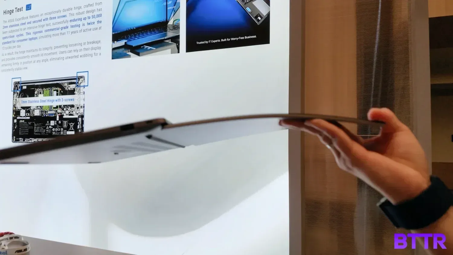 Holding the Expertbook Ultra by the corner of the display.