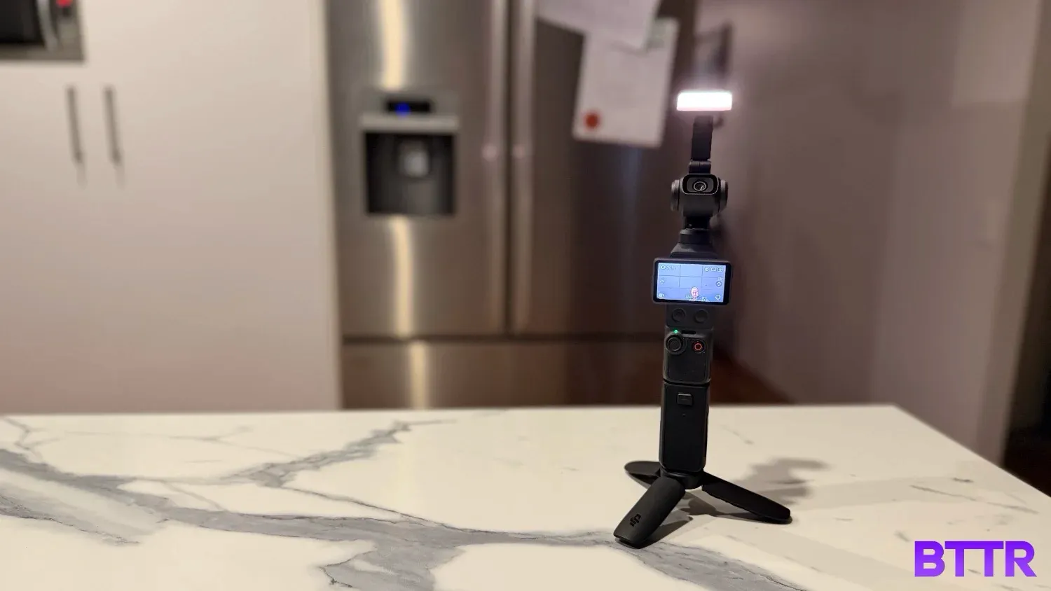 The Osmo Pocket 4 on a tripod attachment in the kitchen