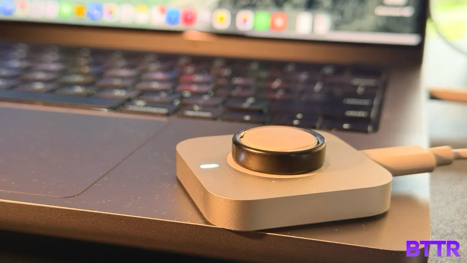 The Ring 5 on its charger on a MacBook