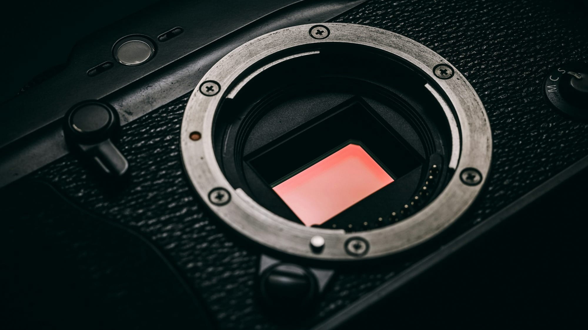 close-up photo of black camera body with no lens so you can see the sensor