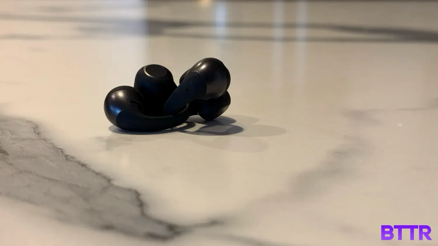 the earbuds themselves wrapped around eachother on a bench
