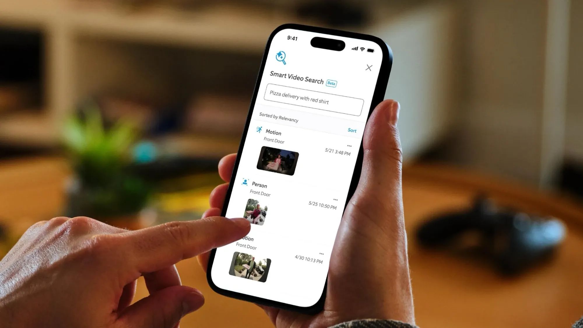 A pair of hands using the Smart Video Search feature on the Ring app on a smartphone