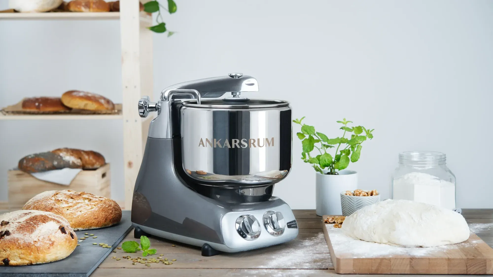 the Ankarsrum Assistent Original on a bench with bread everywhere