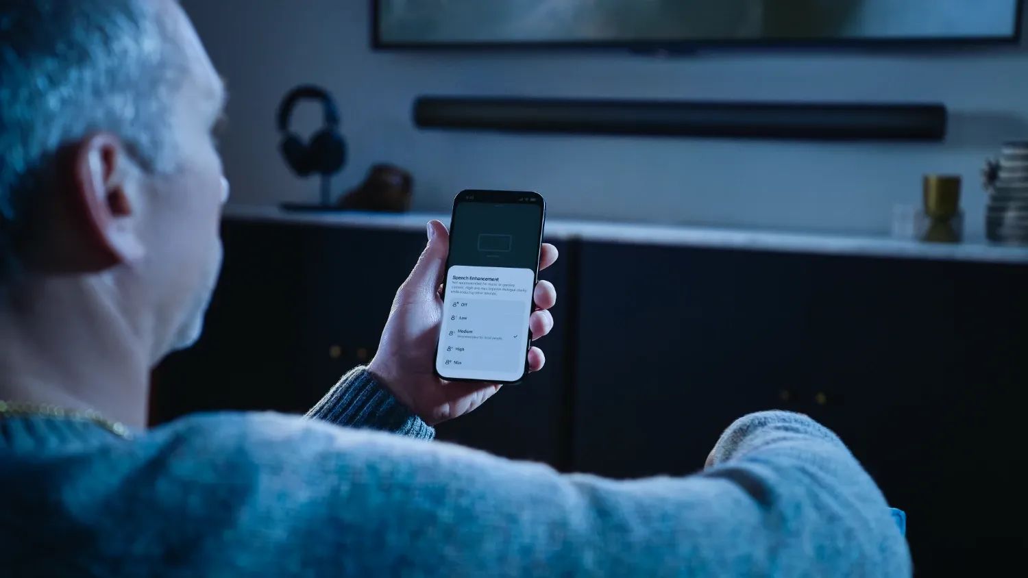 A man using the sonos app to control the speech enhancement