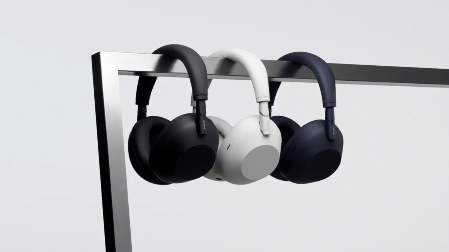 the three colours of the Sony WH-1000XM6 hanging on a metal bar