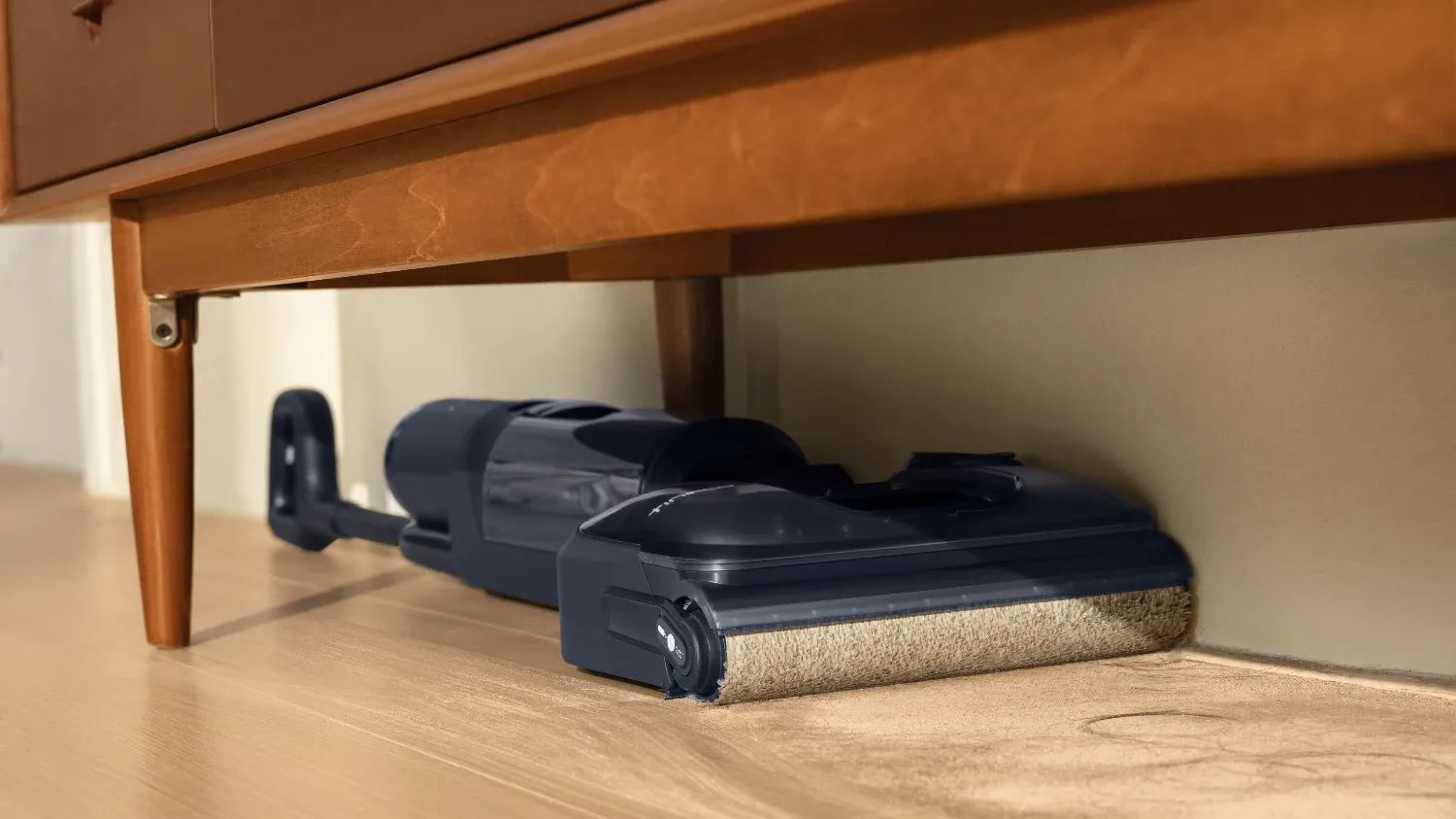 The Tineco Floor One S7 Stretch Deluxe cleaning under some furniture