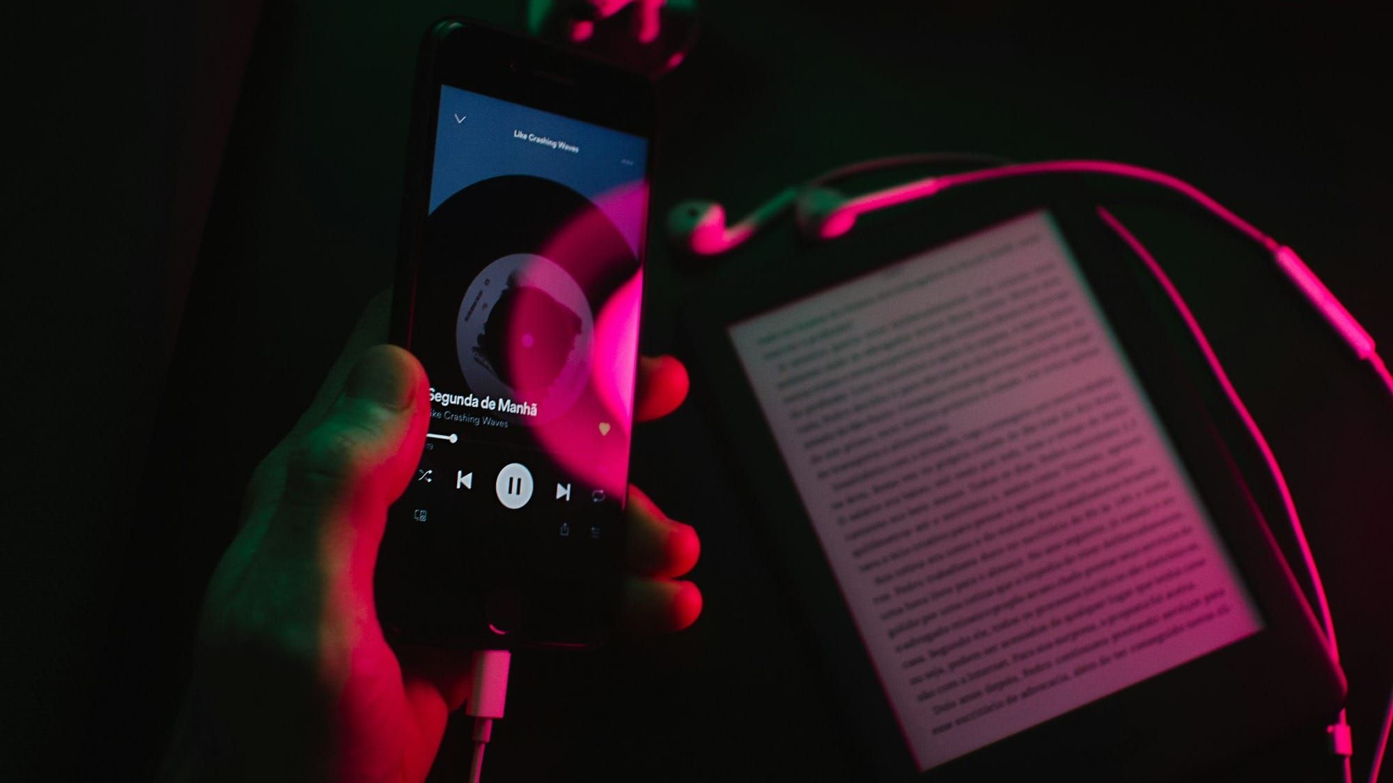 a kindle and a device playing an audiobook