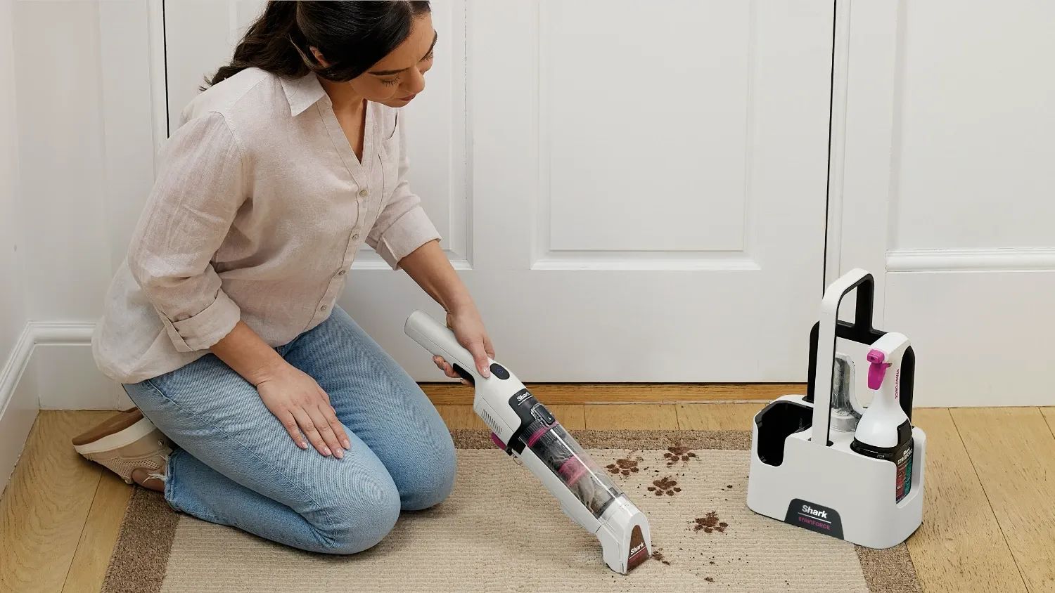 A woman using the StainForce on some pet footprints on a carpet inside