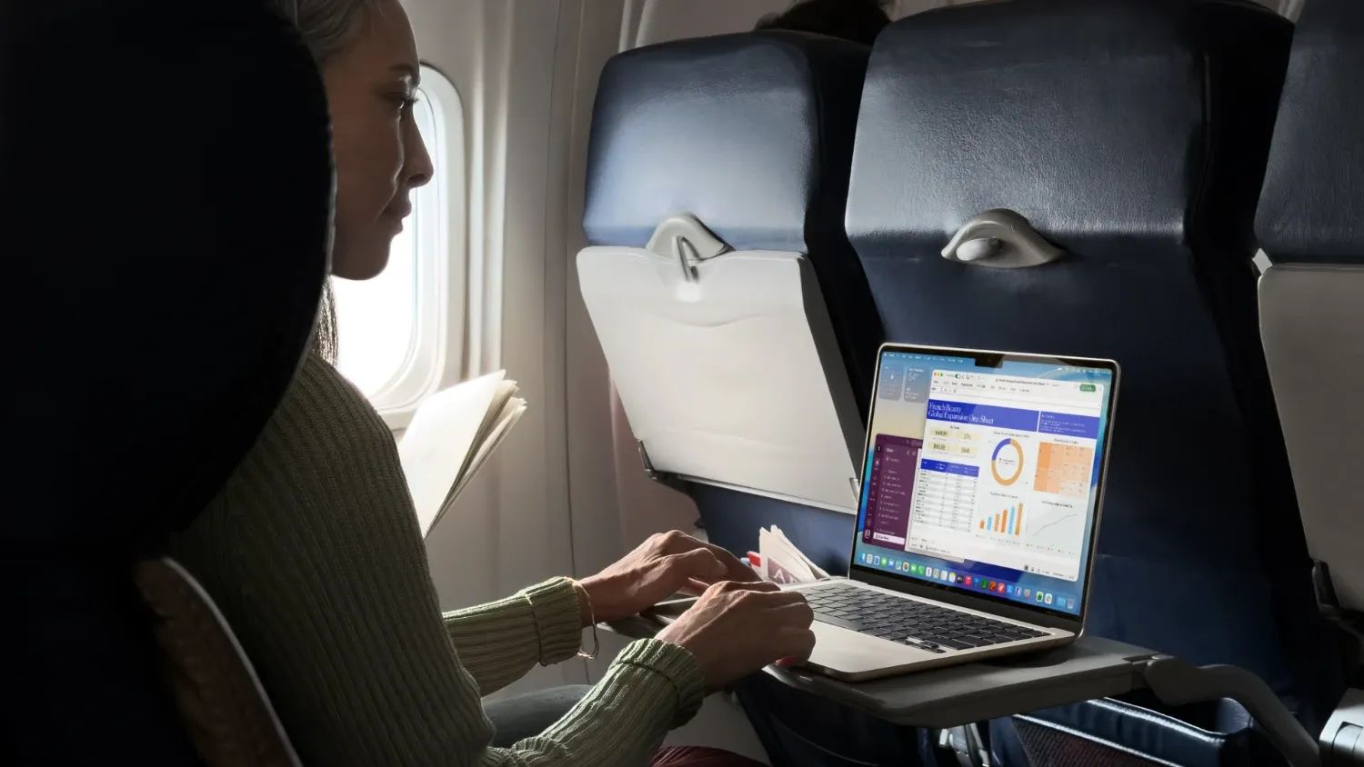 a woman on a plane with the new macbook air