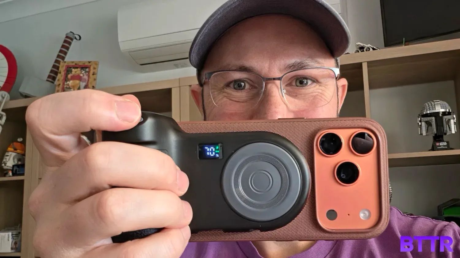 Holding the Belkin Stage PowerGrip with an iPhone 17 Pro attached