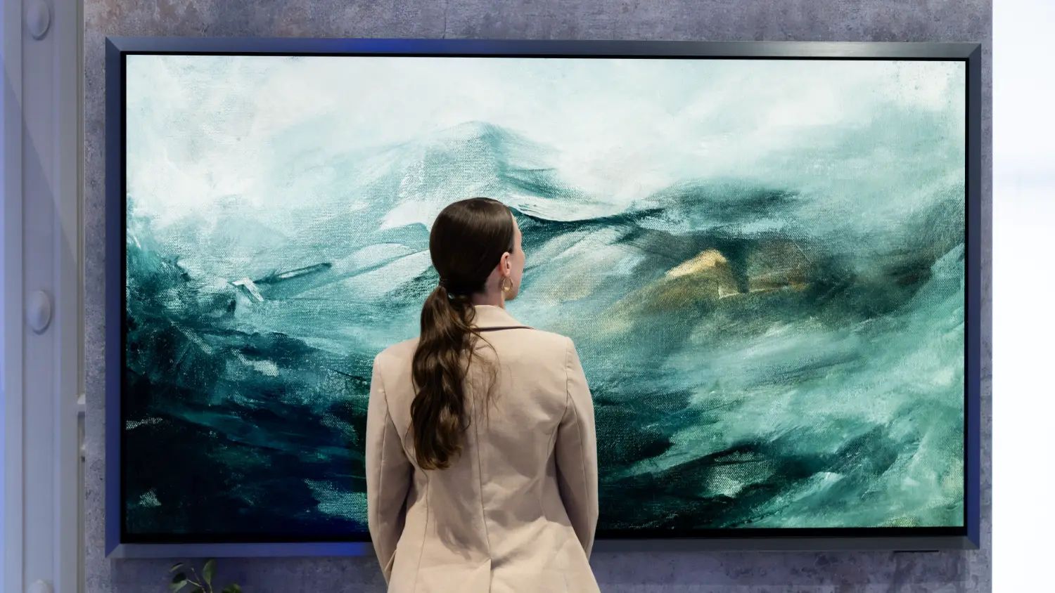 The 83-inch Samsung OLED S95H, displaying a piece of art with a young woman in front admiring the artwork up close.