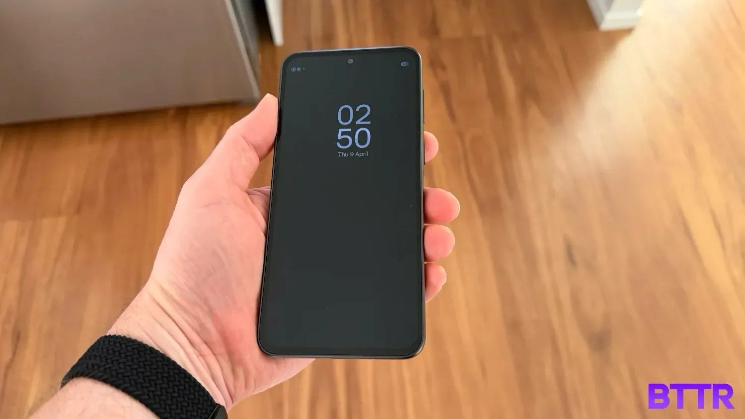 Holding the Galaxy A37 in my hand over vinyl wooden floorboards