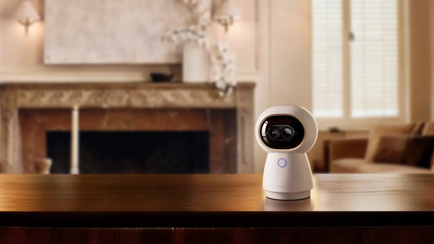the Aqara G350 camera on a table in front os a fireplace and a window.