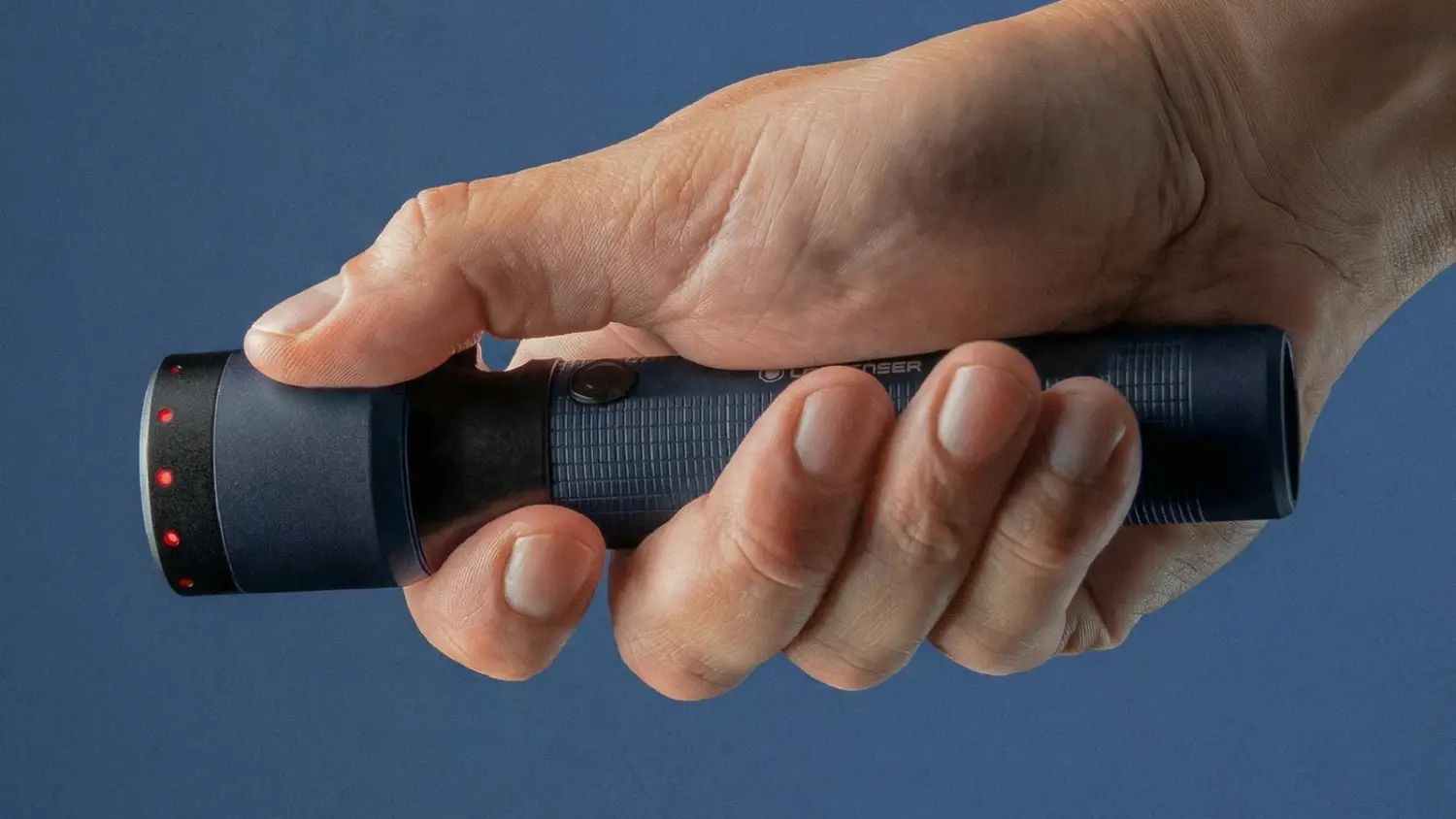A hand holding the Ledlenser P7R 25th anniversary torch