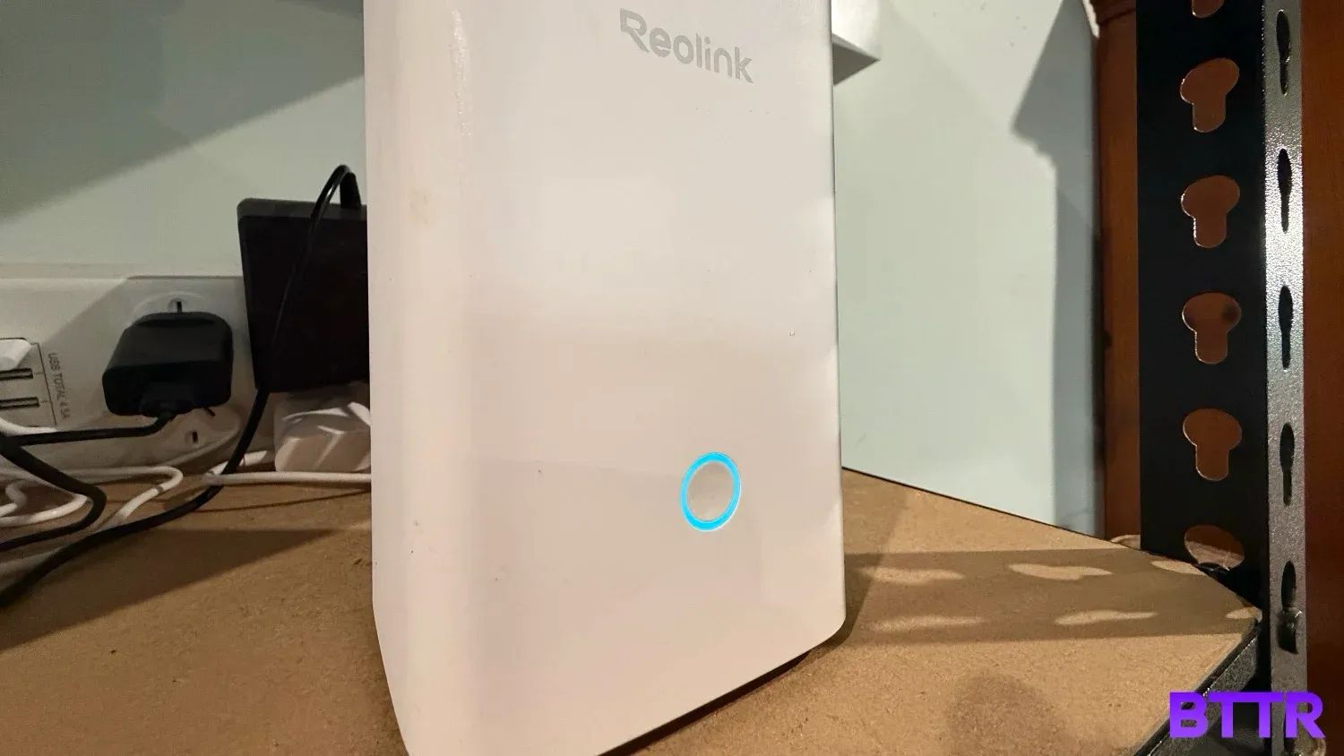 Close up of the front of the ReoLink Hume Hub in a garage with a powerboard behind it