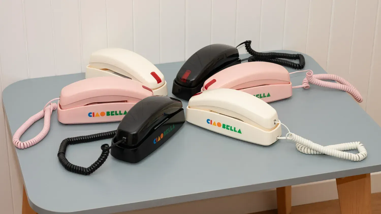six of the Ciao Bella phones on a table in a circle, with black, pink and white models opposite eachother.