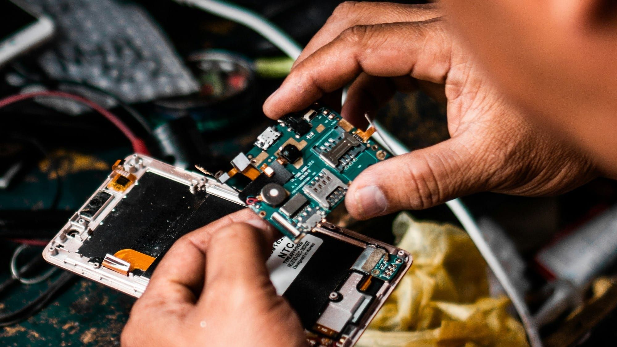 Hands holding a circuit board from a phone