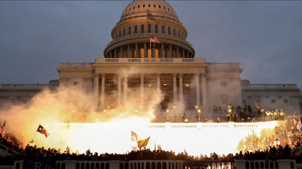 The United States Capitol on January 6th, 2021, besieged and aflame. Photo courtesy of Leah Millis and Reuters.