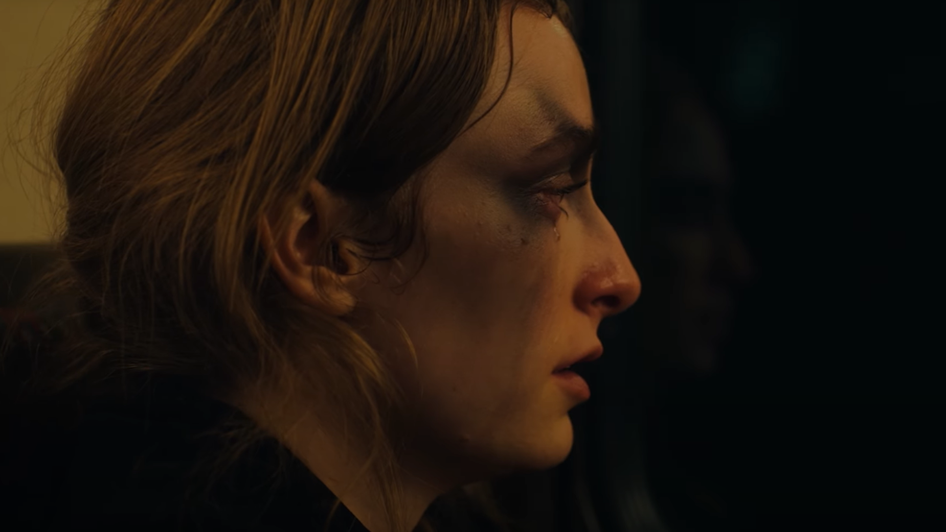 A young woman, Luana, looks pensive in portrait as a tear drips from her eye onto the ash make-up rubbed around her eyes.