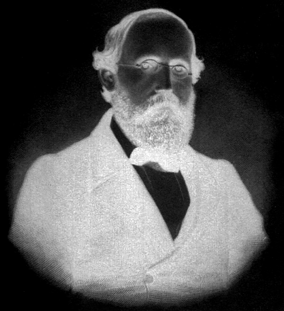 A color-inverted, high-contrast photographic portrait of the mathematician Bernhard Riemann. The negative exposure casts his features in stark, disruptive lighting, serving as a visual metaphor for the spectral geometry of the primes. This stark inversion symbolizes the manuscript's structural rejection of his classical Archimedean continuum in favor of discrete, combinatorial logic.