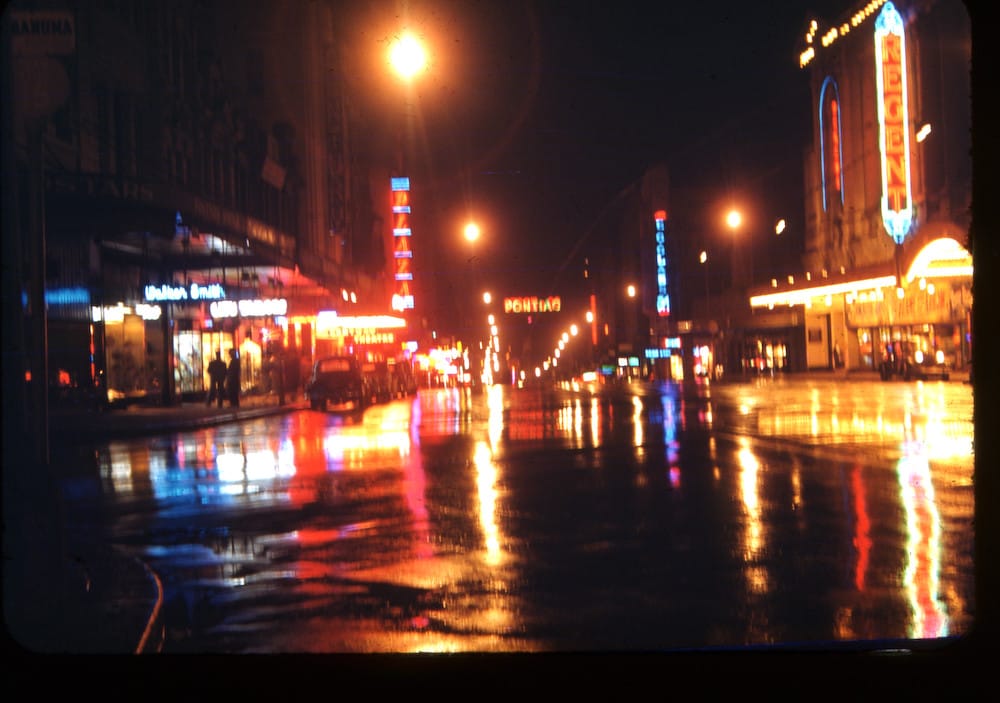 Neon marquees reflecting off the wet pavement of George Street, illuminating the nocturnal social machinery of the city.