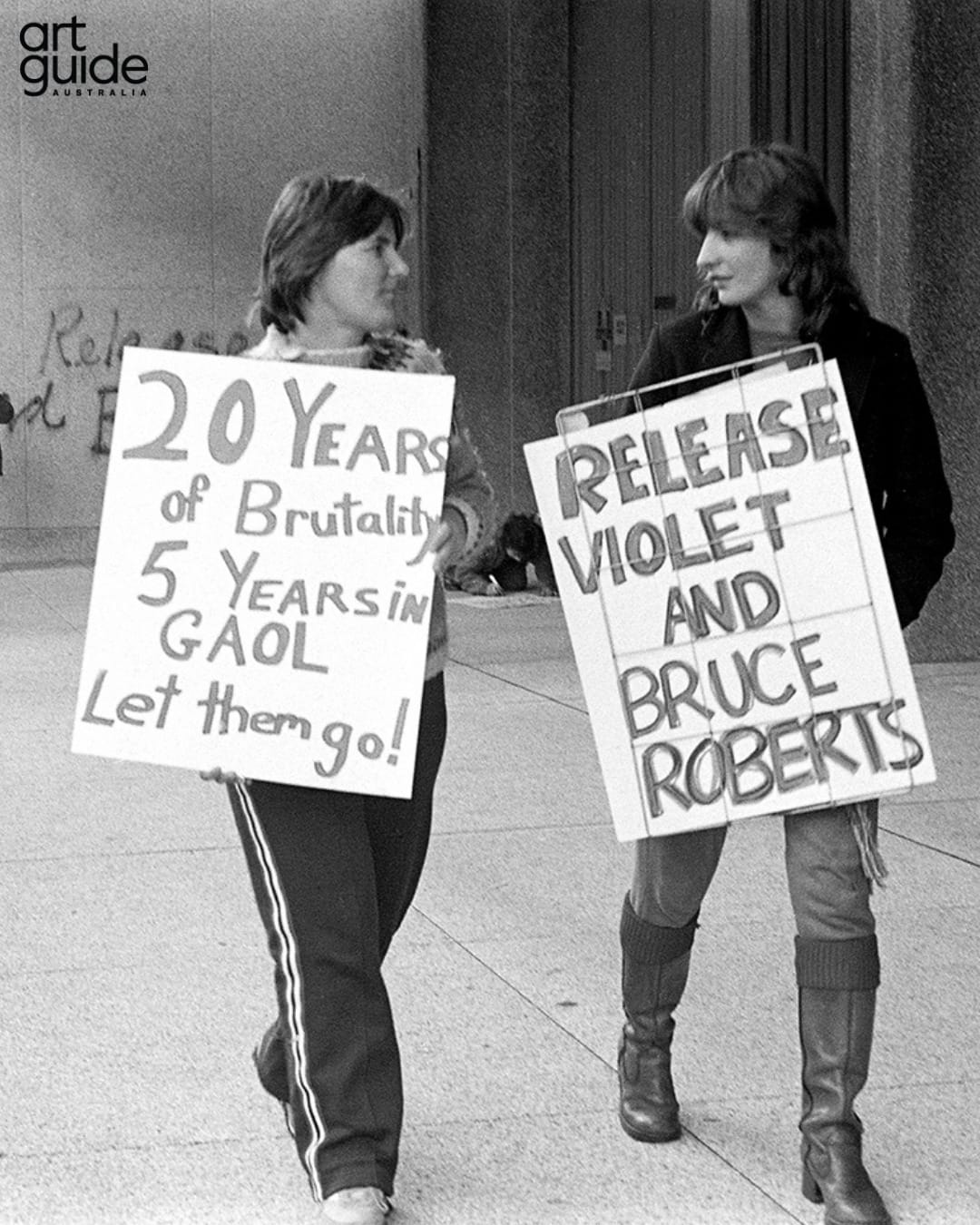 A woman walks with a placard protesting 