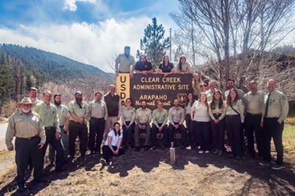 A group of people posing for a photo with a sign

AI-generated content may be incorrect.