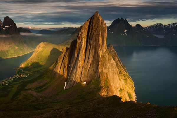 La vetta di Segla sull'isola di Senja nella luce radente, con fiordo e villaggio nel nord della Norvegia