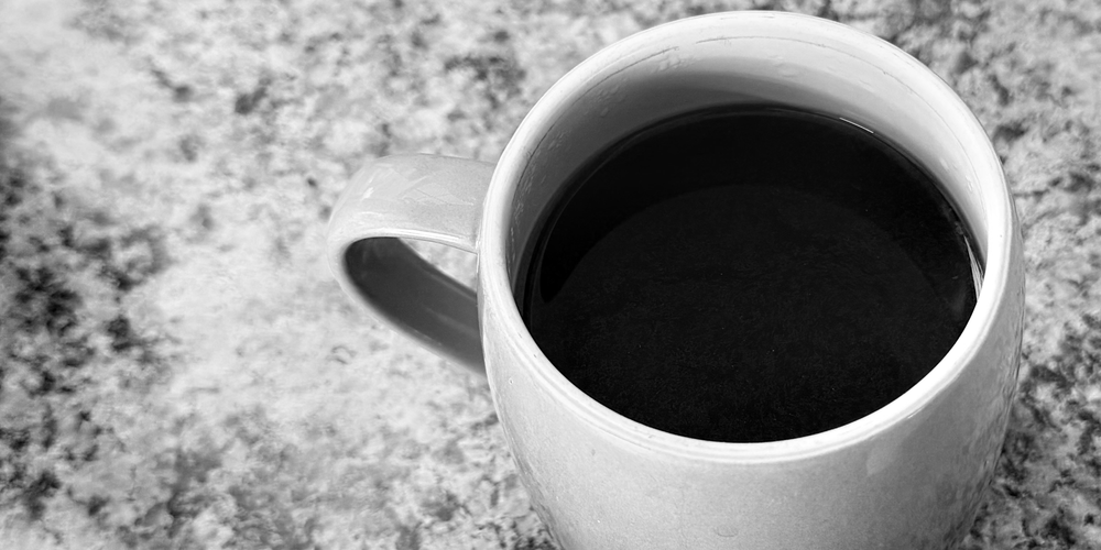 black and white photo of a coffee against a countertop
